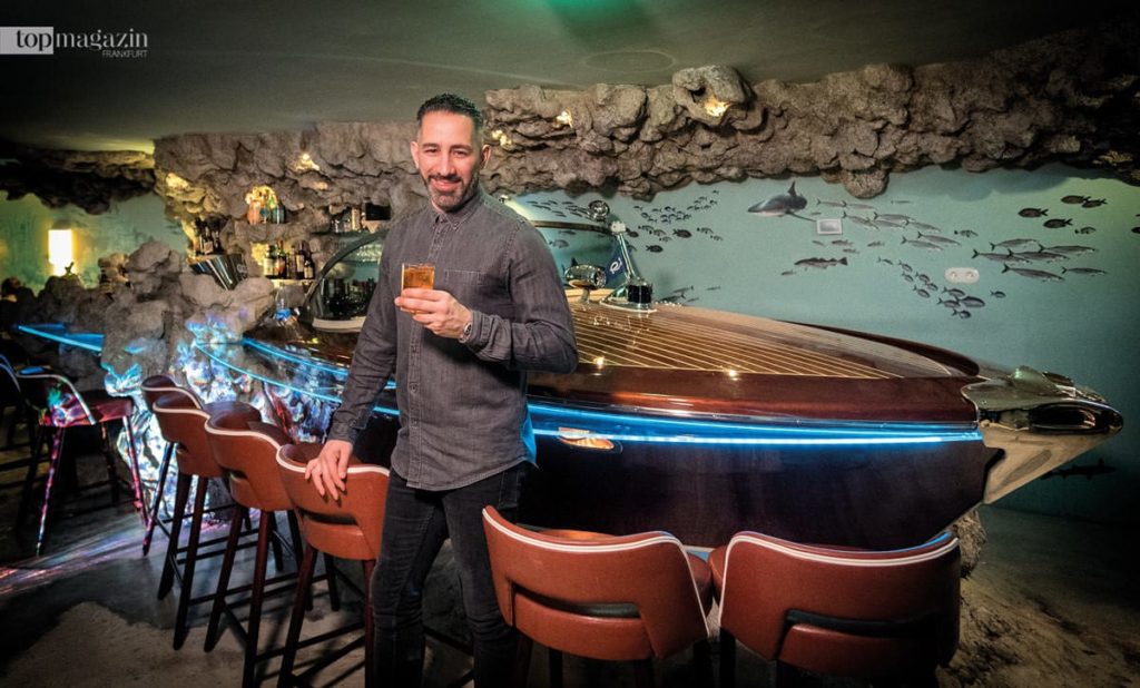 Barchef Farid Rahimi vor dem als Barthresen fungierenden Riva-Boot Barchef Farid Rahimi vor dem als Barthresen fungierenden Riva-Boot