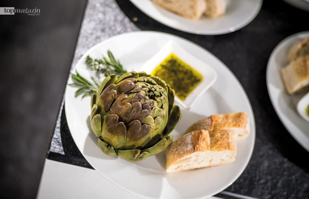 Die Vorspeise - Gedämpfte Artischocke mit Zitronen-Knoblauch-Dip und Baguette Die Vorspeise - Gedämpfte Artischocke mit Zitronen-Knoblauch-Dip und Baguette