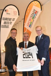 EURO-Botschafter Fredi Bobic, Oberbürgermeister Peter Feldmann und Stadtrat Markus Frank zeigen ein Trikot mit der Aufschrift 'Host City UEFA EURO 2024 Frankfurt am Main'