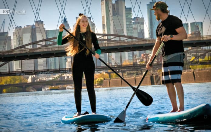 Zum ersten Mal auf dem SUP-Board: Top Magazin-Redakteurin Laura Uebel wagte sich mit SUP-Lehrer Robin Kassel auf den Main