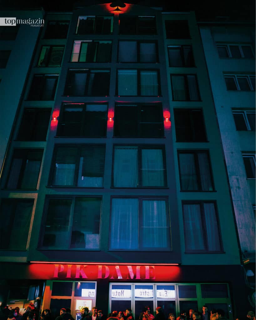 Jedes Wochenende stehen die Nachtschwärmer vor der Bar Schlange. Am Dach des Hauses leuchtet weithin sichtbar das Pik Symbol