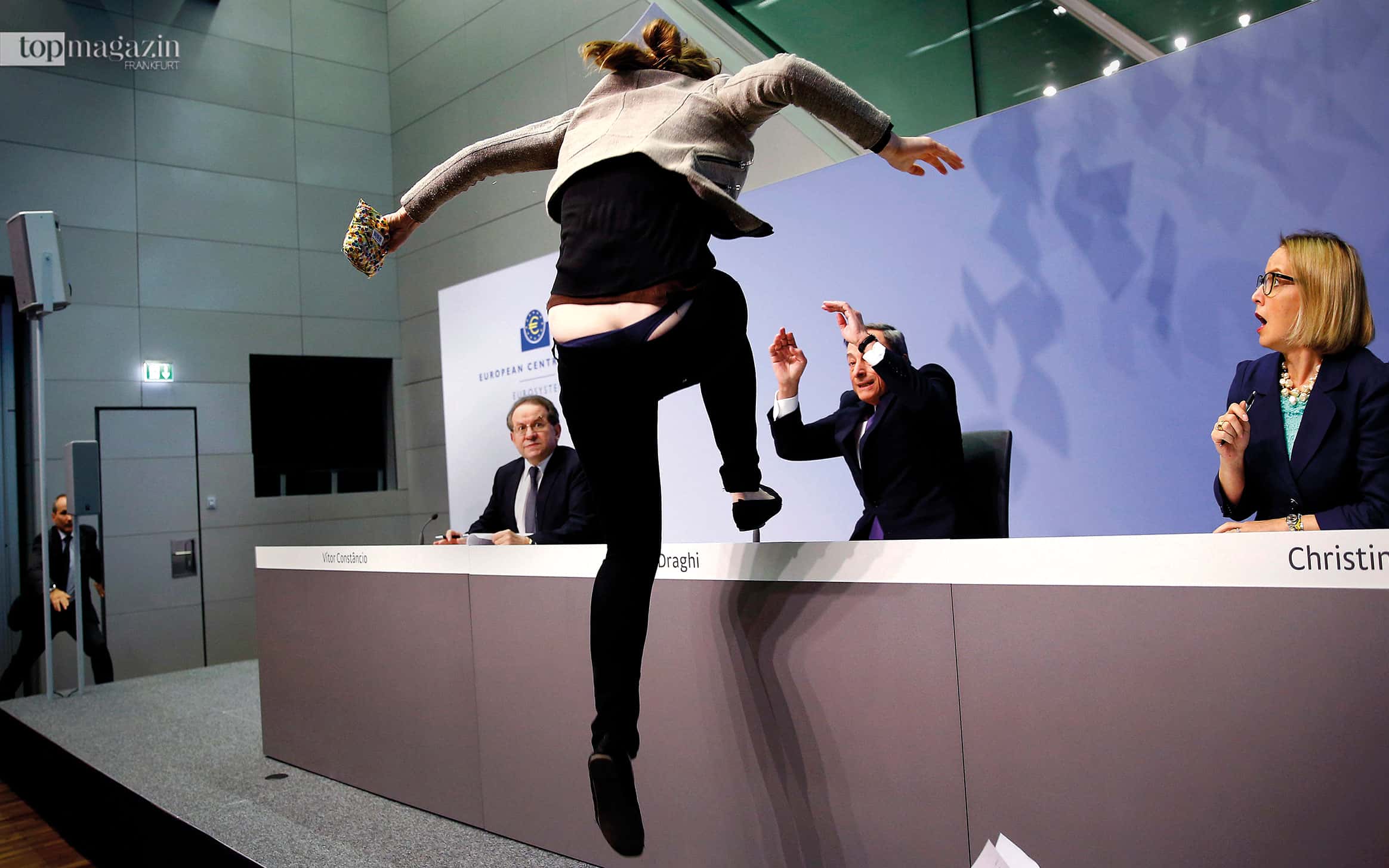 Hände hoch: EZB-Präsident Mario Draghi wird im April 2015 von einer Aktivistin bedrängt, die das Ende „der EZB-Diktatur“ forderte. Eigentlich sind solche Pressekonferenzen nach der Tagung des Zentralbankrats Routinesachen. Aber ein guter Fotograf hat immer den Finger am Auslöser.