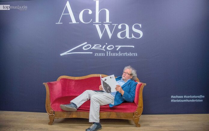 Caricatura-Chef Achim Frenz posiert auf dem berühmten Loriot-Sofa für die Fotografen (Foto: Bernd Kammerer)