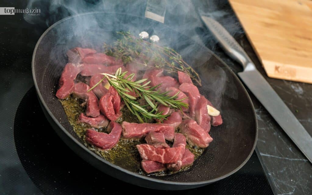 Die Rinderfiletstreifen werden mit Rosmarinzweigen scharf angebraten