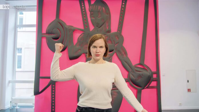 Sonja Yakoleva posiert vor ihrem Scherenschnitt „Pink sexy gym boot camp“ im Frankfurter Kunstverein (Foto: Bernd Kammerer)