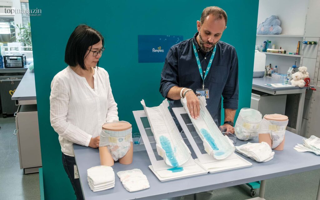 Wissenschaftlerin Wei Sing Long und Forschungs- und Entwicklungs-Direktor Dirk Saevecke demonstrieren den neuartigen Auslaufschutz mit dem Stop- und Schutztäschchen
