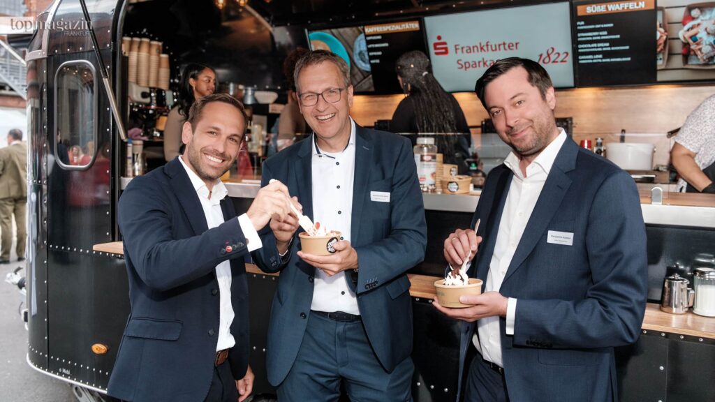 Sebastian Hau (Frankfurter Sparkasse), Reinhard Kromer und Benjamin Asmus (beide Peiker Holding) genießen die frischen Waffeln mit Erdbeeren vom Food Truck
