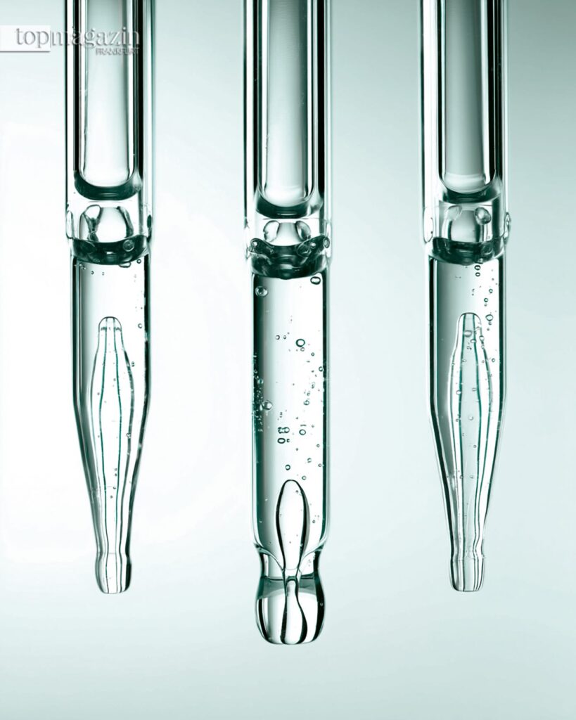 Drei gläserne Labor-Pipetten symbolisieren die präzise wissenschaftliche Hautforschung und Peptid-Technologie, die Clinuvel für seine Produkte nutzt.