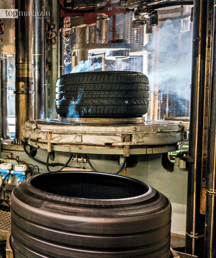 Eine große, elektrisch betriebene Heizpresse im Pirelli Werk formt unter Dampf einen Reifenrohling während der Vulkanisierung.