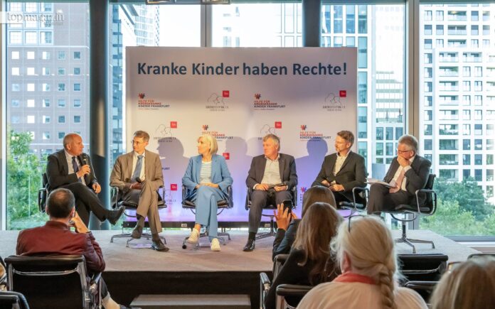 Podiumsdiskussion in Frankfurt zum Thema kranke Kinder. Sechs Experten, darunter Hessens Innenminister Prof. Roman Poseck, diskutieren auf einer Bühne vor Publikum.