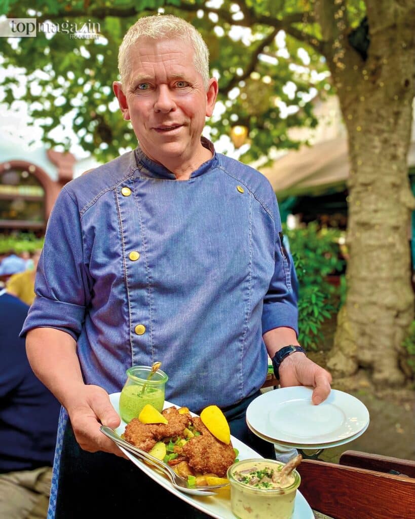 Gastronom Frank Winkler präsentiert stolz ein Frankfurter Schnitzel mit einem Töpfchen Grüner Soße in seinem Wirtshaus Lorsbacher Thal.