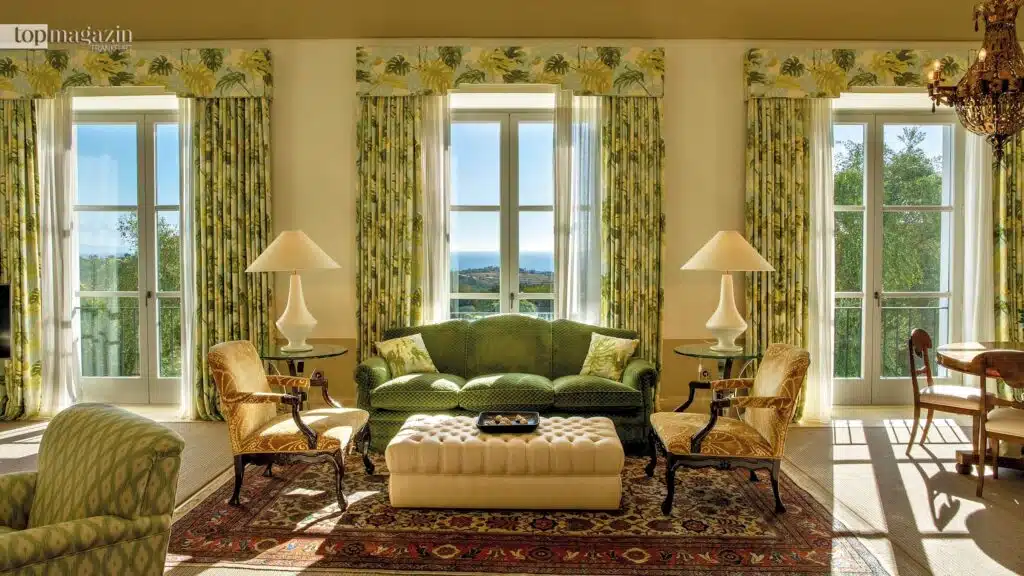 Exklusive Suite in der Finca Cortesin mit klassischen Möbeln, deckenhohen Fenstern und Veranda.