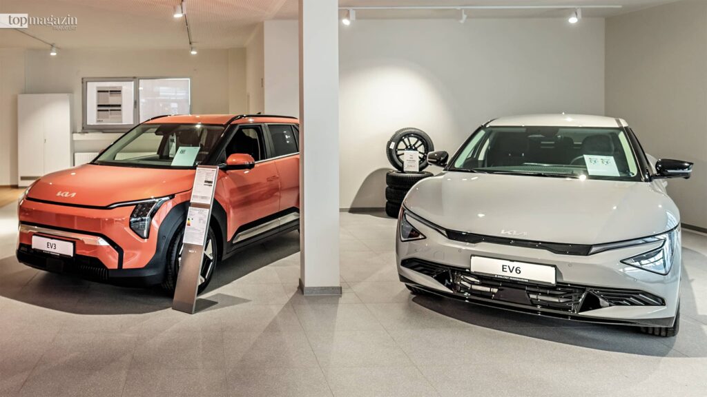 Die vollelektrischen Kia Modelle EV3 und EV6 parken nebeneinander im hellen Verkaufsraum der Hessengarage.