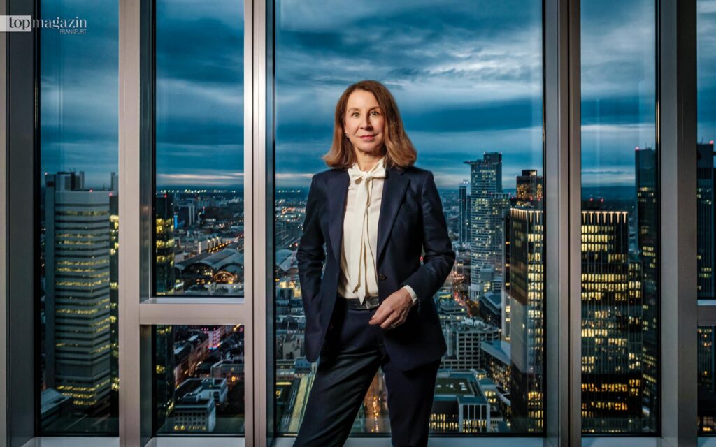 Dr. Gertrud R. Traud, Chefvolkswirtin der Helaba, vor der Frankfurter Skyline in der Abenddämmerung.