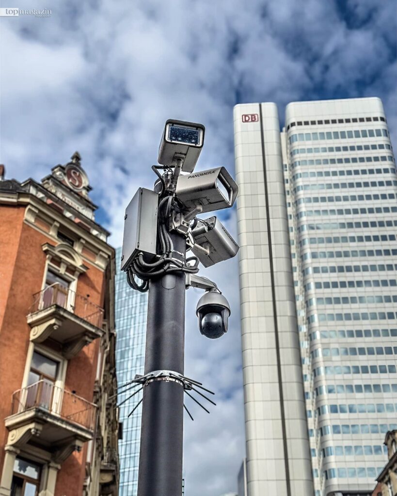 KI-gestützte Videoschutzanlage an einem Mast in Frankfurt mit dem DB-Hochhaus im Hintergrund.