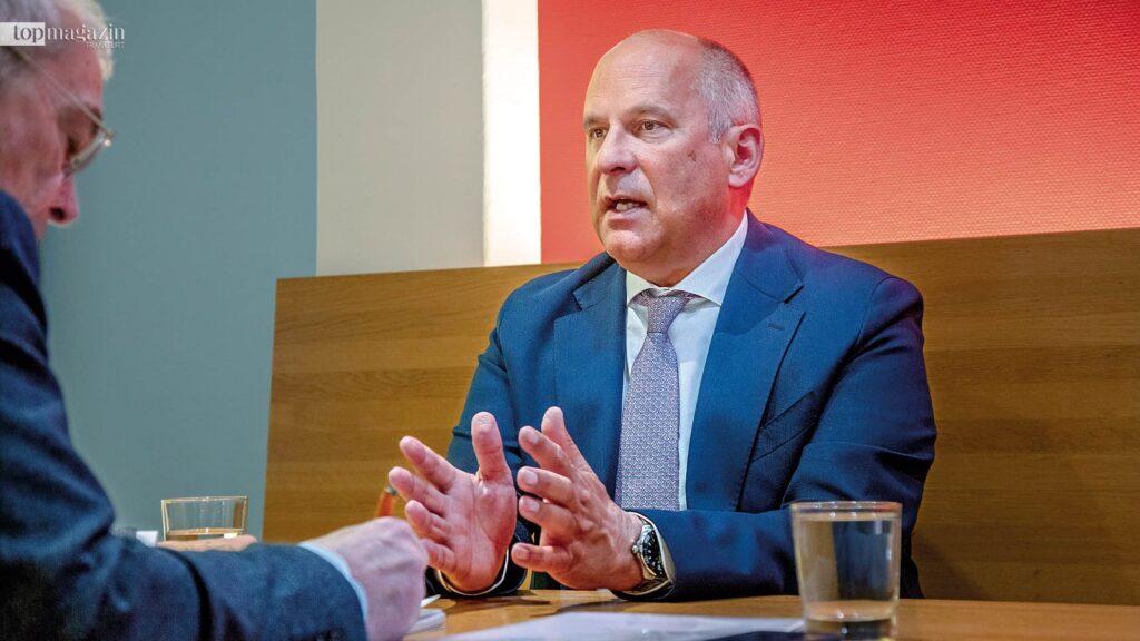Innenminister Roman Poseck im Gespräch am Tisch.