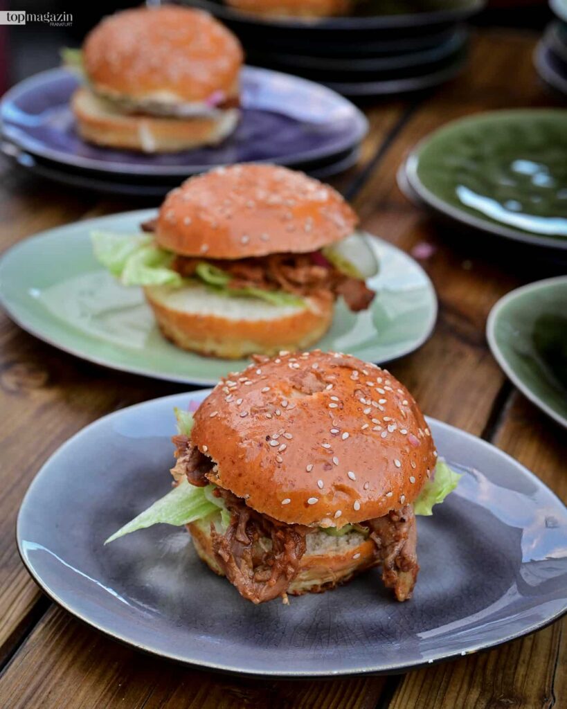 Pulled-Pork-Burger auf Tellern bei den Live-Cooking-Stations des Sommerfests