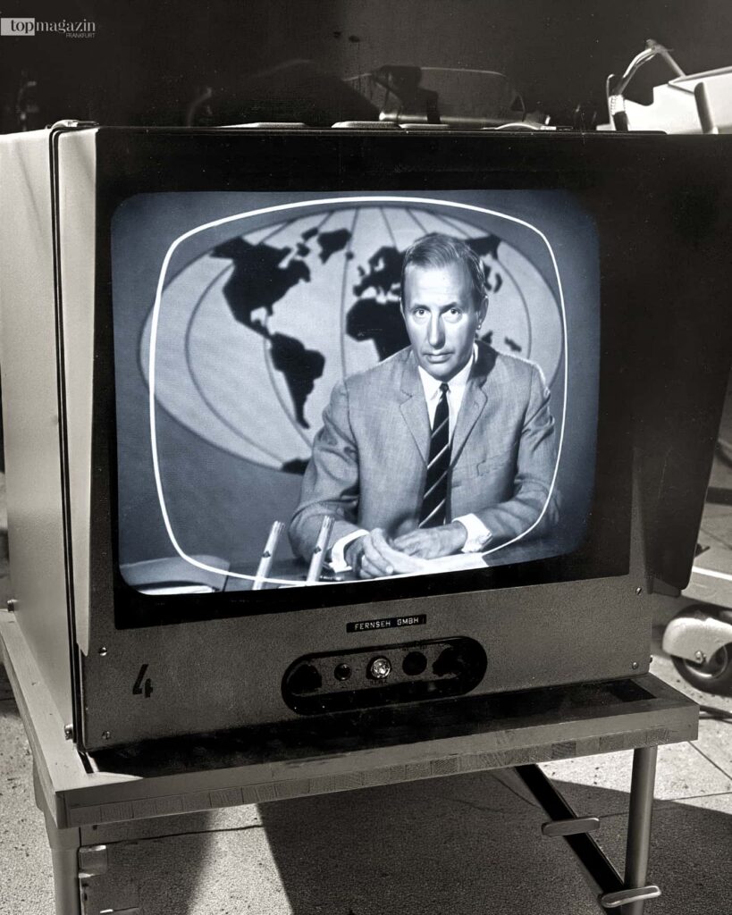 Karl-Heinz Köpcke, bekannt als Mr. Tagesschau, liest die Nachrichten auf einem historischen Röhrenfernseher