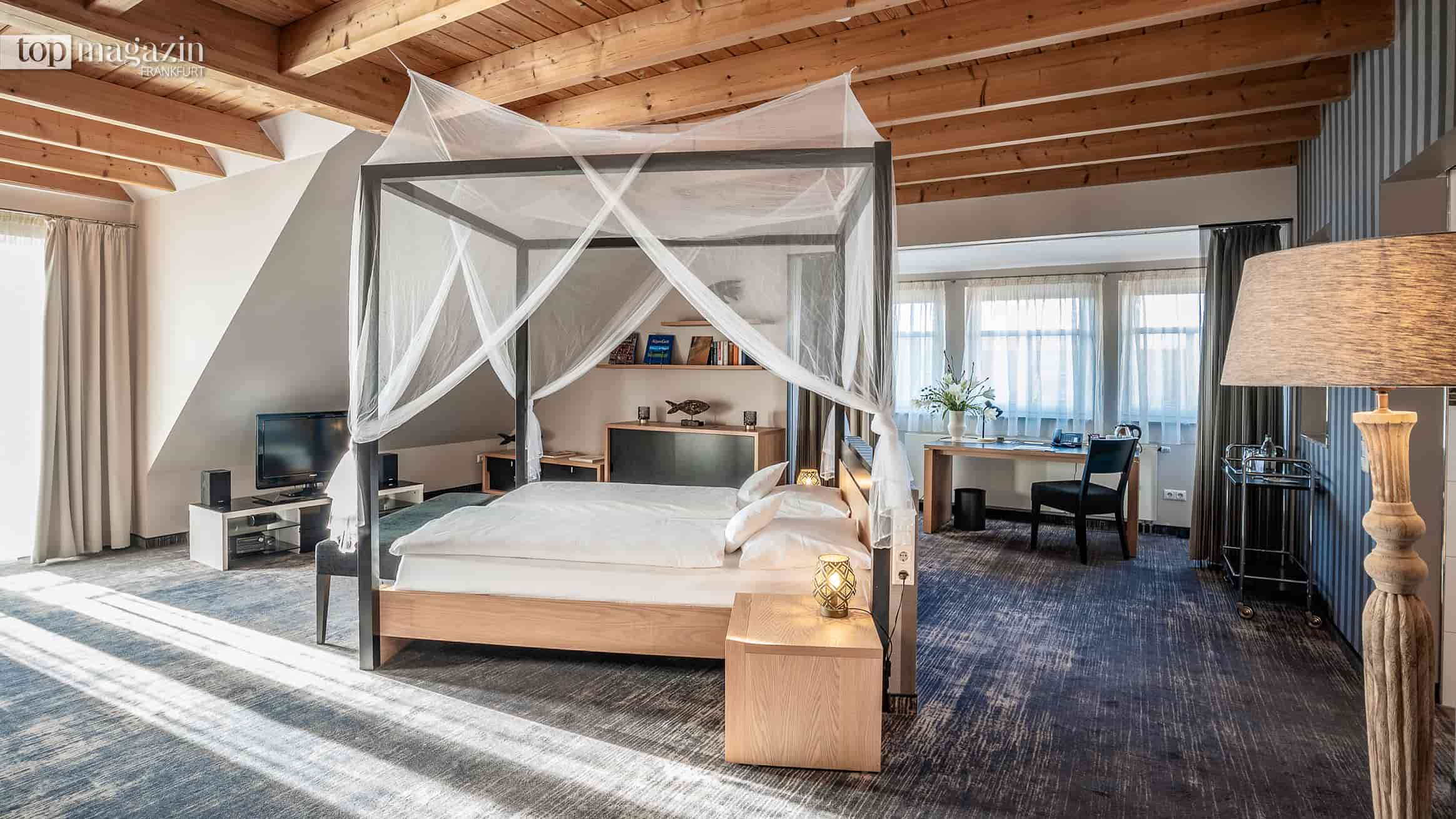 Lichtdurchflutete Chalet-Suite mit Himmelbett und Holzbalkendecke im Seehotel Niedernberg