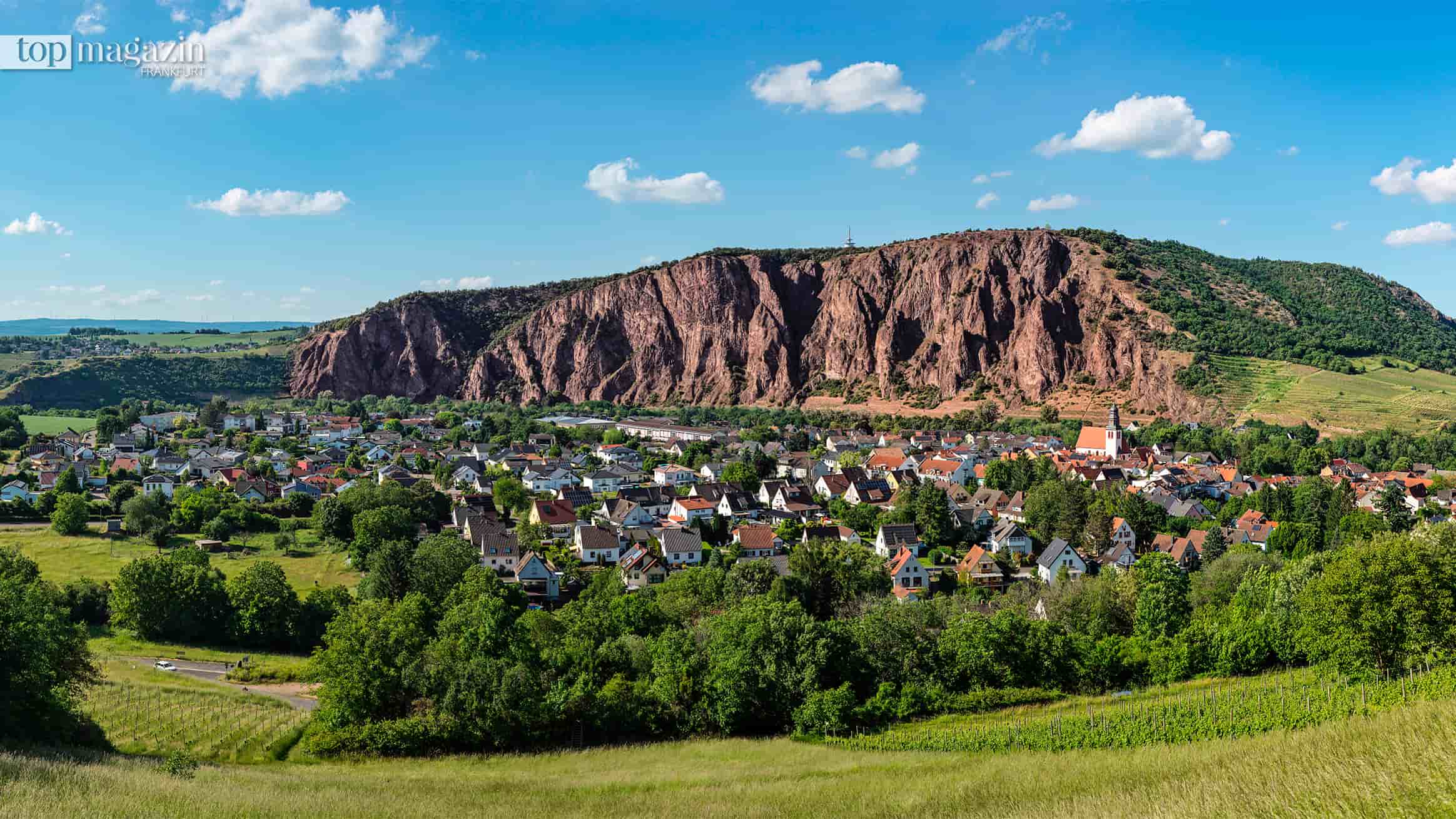 Die rote Steilwand des Rotenfels erhebt sich über dem Ort Bad Münster am Stein-Ebernburg im Nahetal