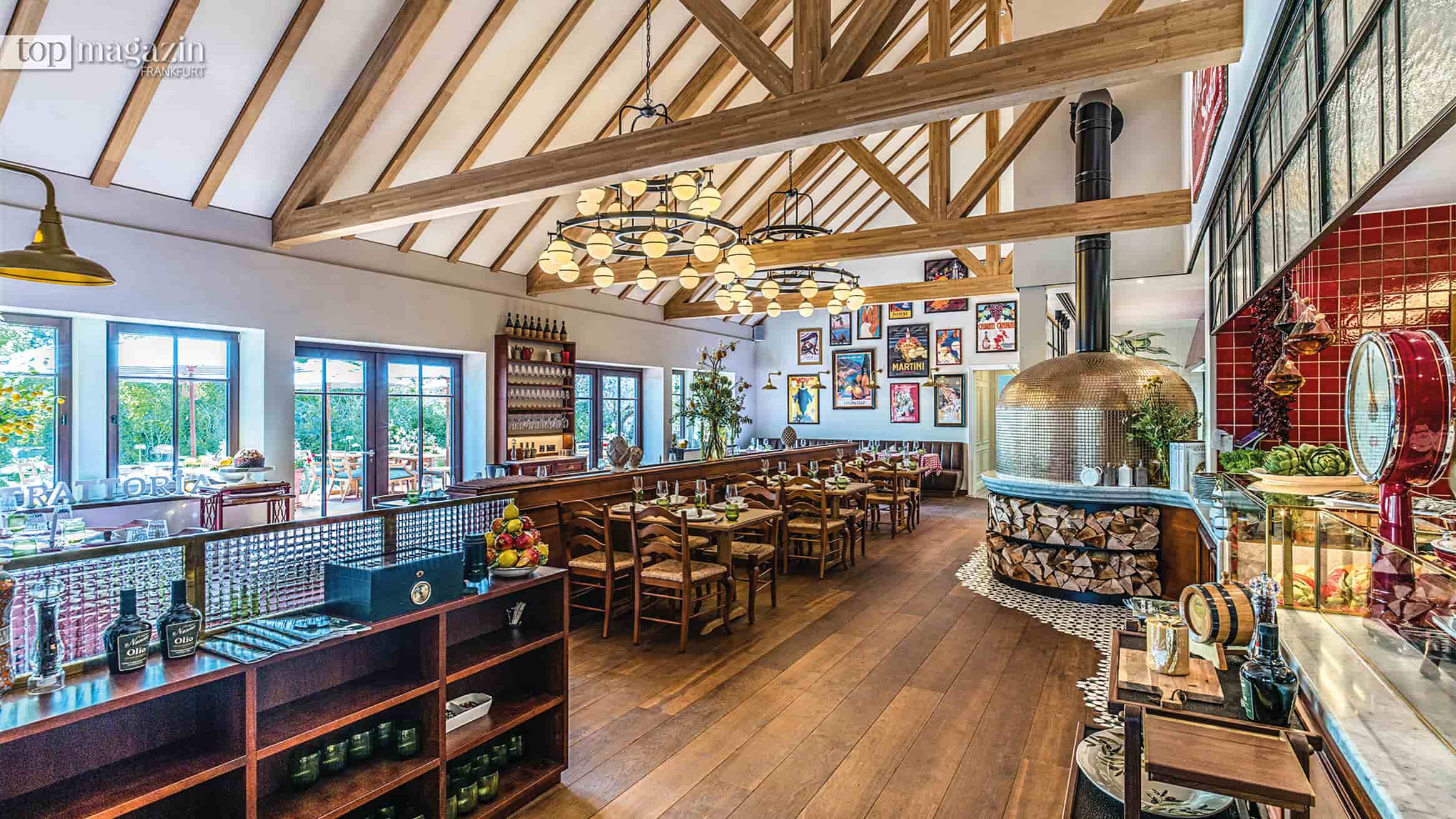 Gastraum der Trattoria Nonna mit offenem Dachstuhl, Holzboden und Steinofen auf dem Hofgut Dagobertshausen